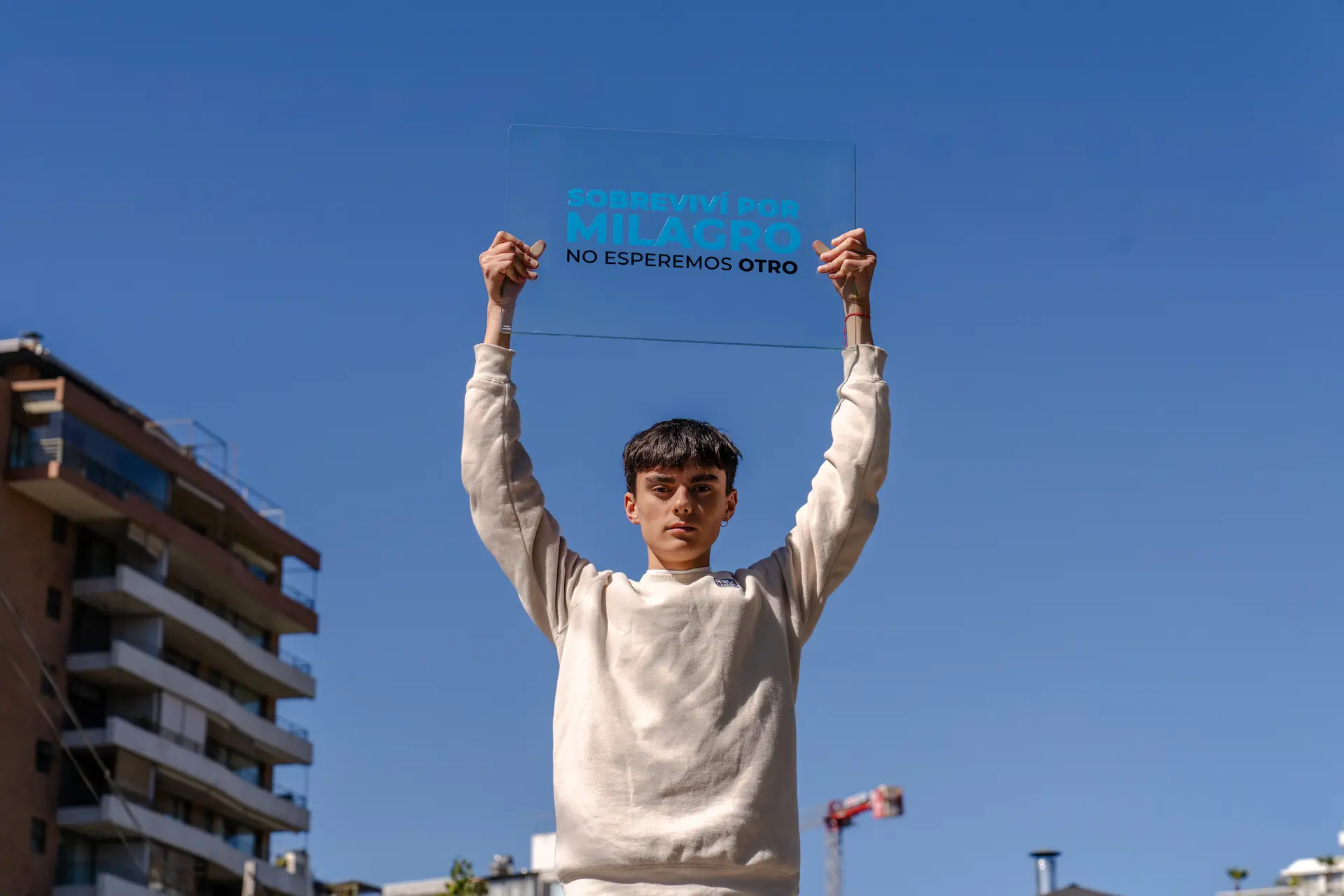 Joven sosteniendo un vidrio con el mensaje: Sobreviví por milagro